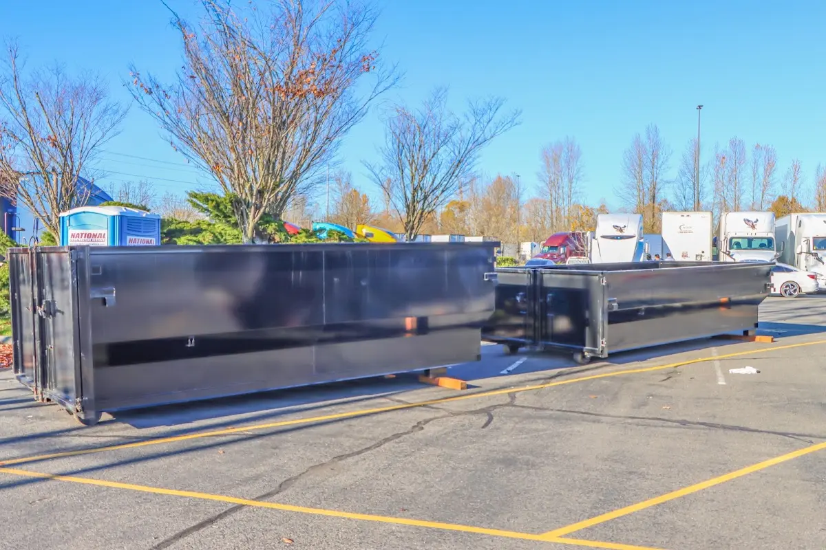 Professional dumpster rental service with roll-off container on residential driveway in Port Washington